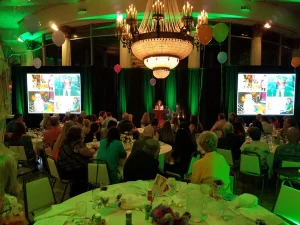 Corporate banquet event with stage presentation and green lighting setup by Lucas Productions USA