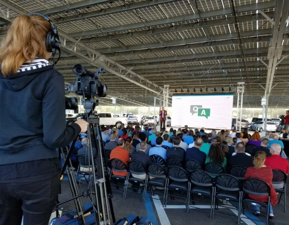 Video technician filming outdoor corporate event with professional AV camera setup by Lucas Productions USA
