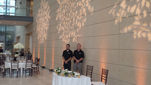 Stpete Museum event setup with elegant uplighting and floral wall projections beside banquet tables