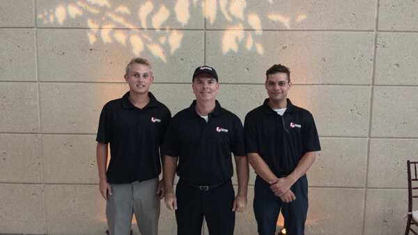 stpete-museum staff posing in front of wall with decorative light projections"