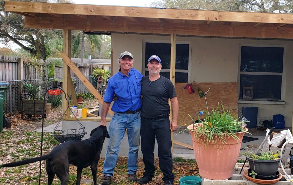 Lucas Productions founder, with a family member standing in front of a construction project, representing the legacy of excellence in custom building and audio-visual services