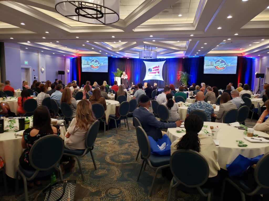 Lucas Productions Audio Visual managing live corporate event with stage, screens, and audience seating in Orlando conference venue.