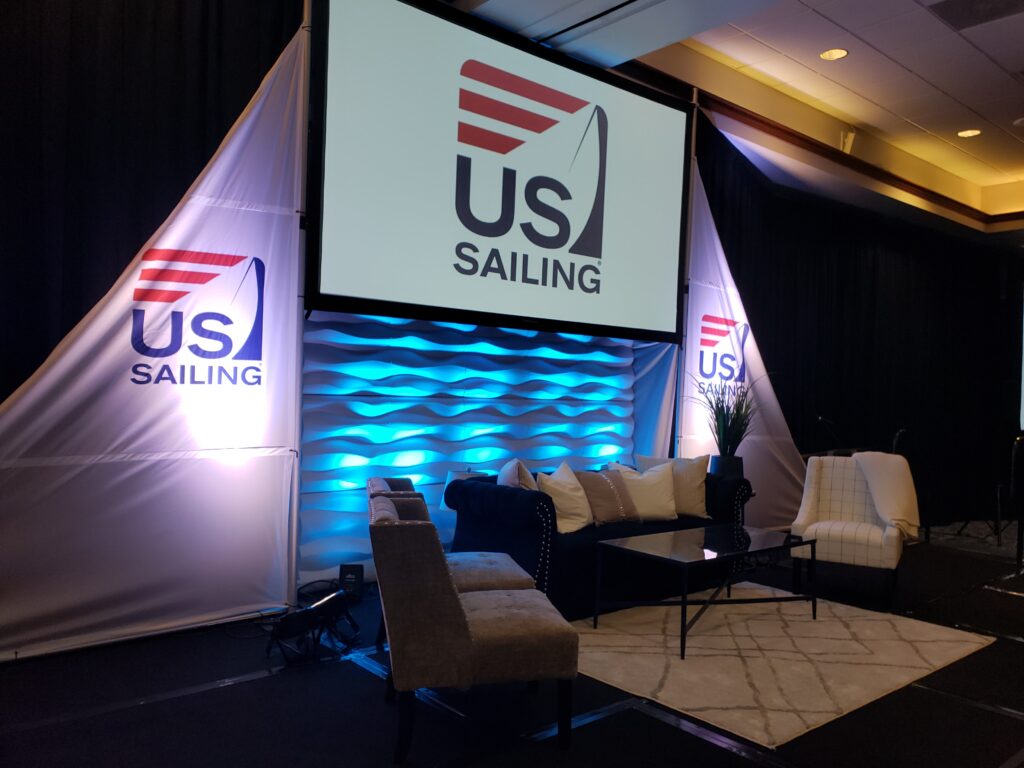 Lucas Productions USA stage setup for US Sailing event with professional lighting, video screens, and AV production.