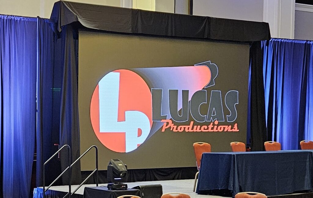 Lucas Productions USA branded LED video wall display at corporate event stage setup.