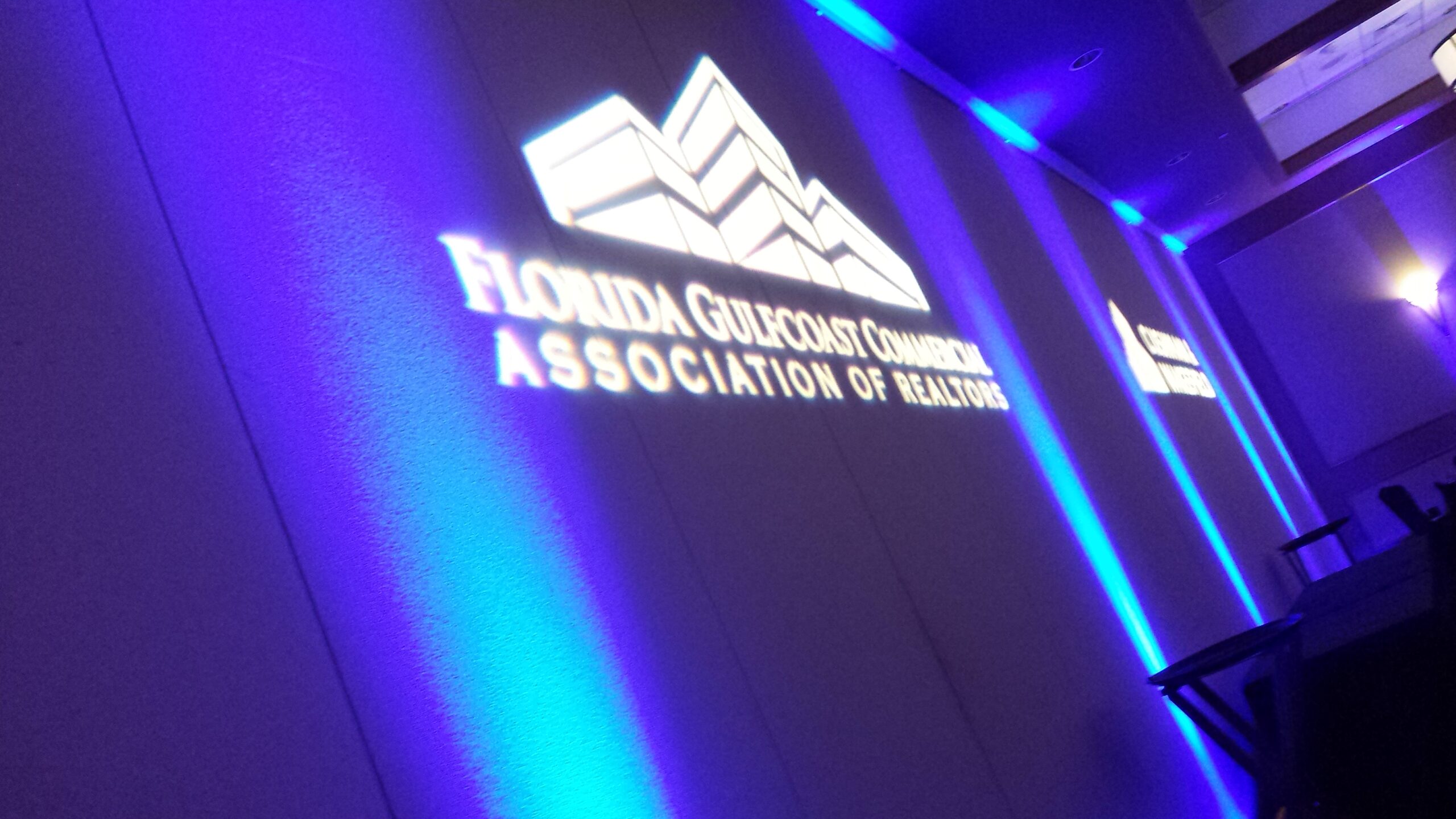 Florida Gulfcoast Commercial Association of Realtors logo projection with blue event lighting by Lucas Productions USA.