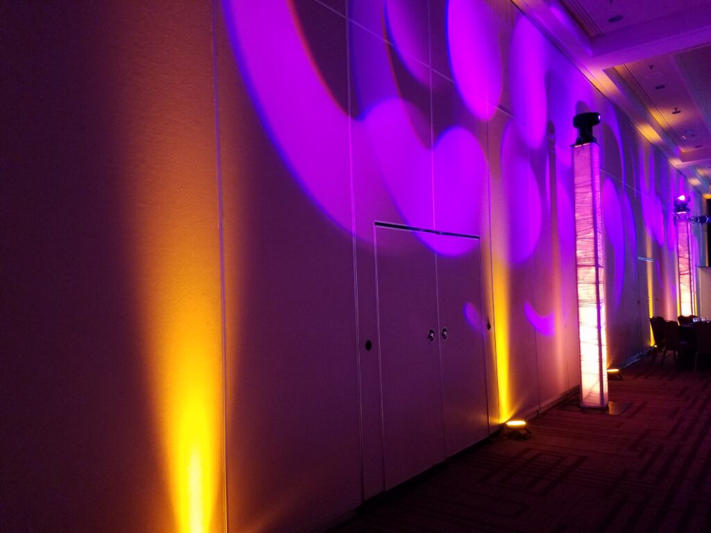 Colorful LED uplighting with purple, green, and amber event lighting design by Lucas Productions USA.
