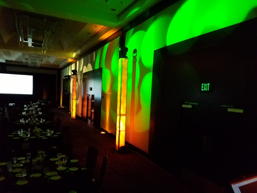 Colorful LED uplighting with green, orange, and amber event lighting design with LED Wall setup by Lucas Productions USA.